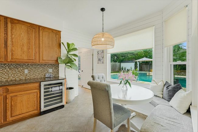Dining space with wine cooler, plenty of natural light, and light tile patterned floors | Image 12