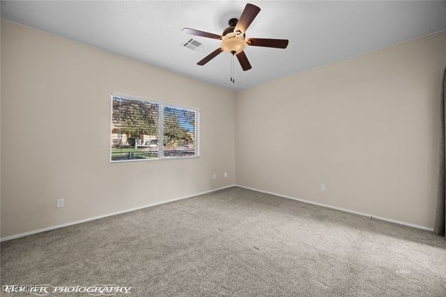Carpeted empty room with baseboards, visible vents, and ceiling fan | Image 21