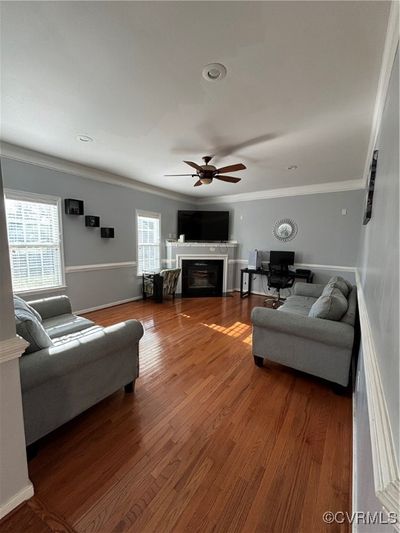 Living room with hardwood / wood-style floors, crown molding, and ceiling fan | Image 3