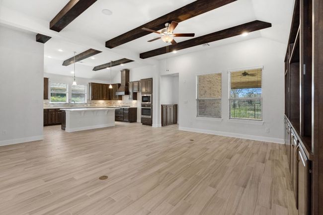 Unfurnished living room with light wood-style flooring, a ceiling fan, and baseboards | Image 12