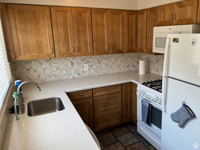 Kitchen with white appliances, cabinets, and backsplash | Image 8