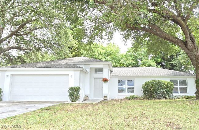 View of front facade with driveway, a garage, a shingled roof, a front yard, and stucco siding | Image 37