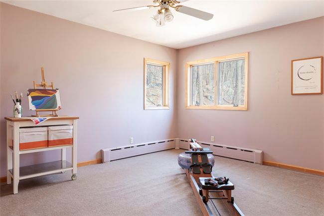 Miscellaneous room with carpet flooring, a baseboard radiator, baseboards, and ceiling fan | Image 22