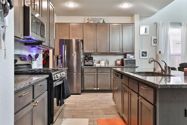 The farmhouse sink and gas oven enhance the home's theme of convenience and functionality. | Image 8