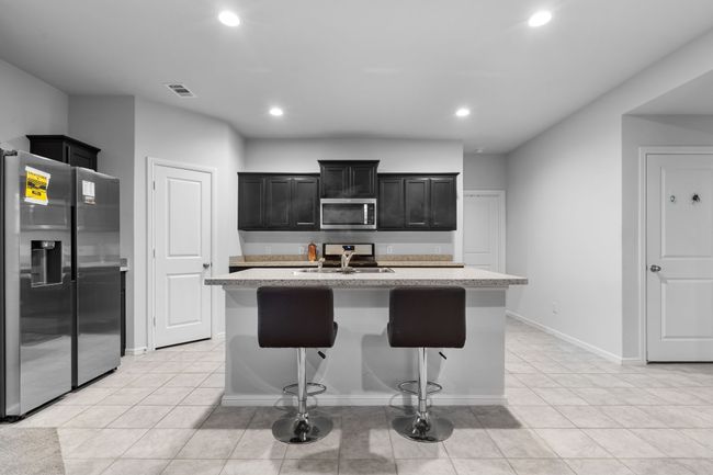 Kitchen featuring a sink, light countertops, visible vents, and stainless steel appliances | Image 7