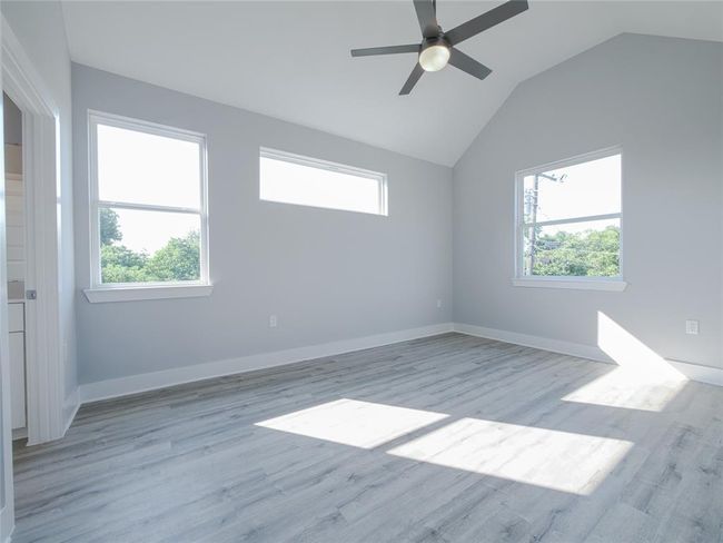 Spare room with healthy amount of natural light, vaulted ceiling, and light wood-type flooring | Image 16