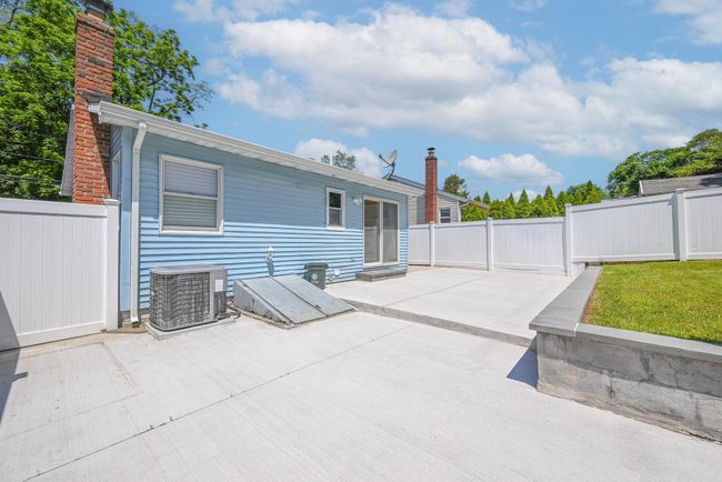 Rear view of property featuring a chimney, a patio area, and a fenced backyard | Image 17