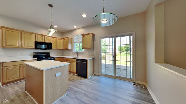 kitchen featuring black appliances, light brown cabinetry, a sink, light countertops, and recessed lighting | Image 8