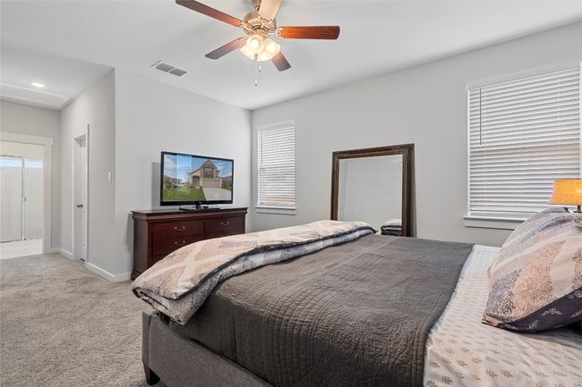 Bedroom with light carpet, multiple windows, baseboards, and a ceiling fan | Image 19