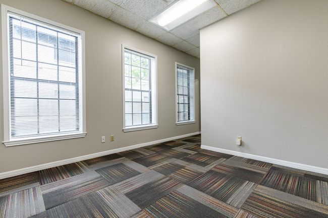 Empty room featuring dark colored carpet and a paneled ceiling | Image 5