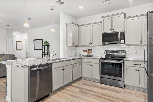 Kitchen with stainless steel appliances, a peninsula, light wood-type flooring, tasteful backsplash, and open floor plan | Image 18