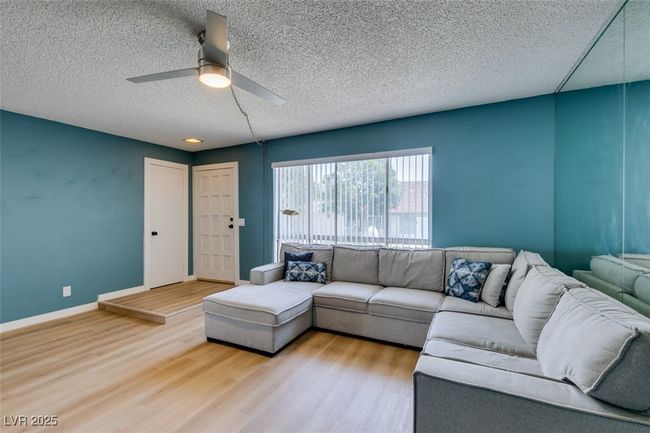 Living area featuring ceiling fan, a textured ceiling, and wood finished floors | Image 8