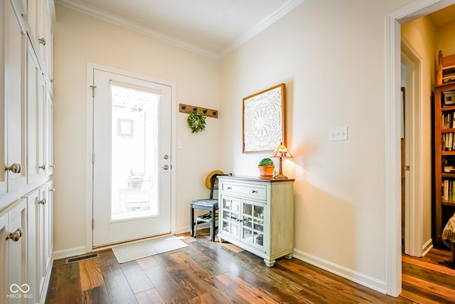 entryway with dark wood-type flooring, ornamental molding, and baseboards | Image 5