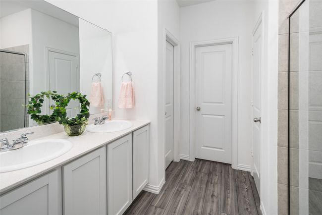 Bathroom with wood finished floors, double vanity, and tiled shower | Image 15
