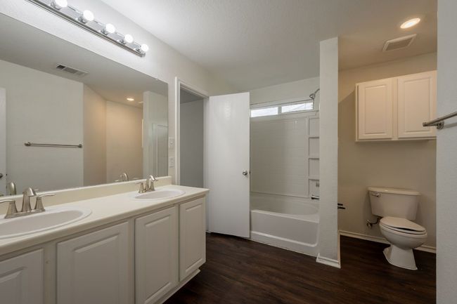 Full bath with toilet, wood finished floors, double vanity, recessed lighting, and tub / shower combination | Image 18