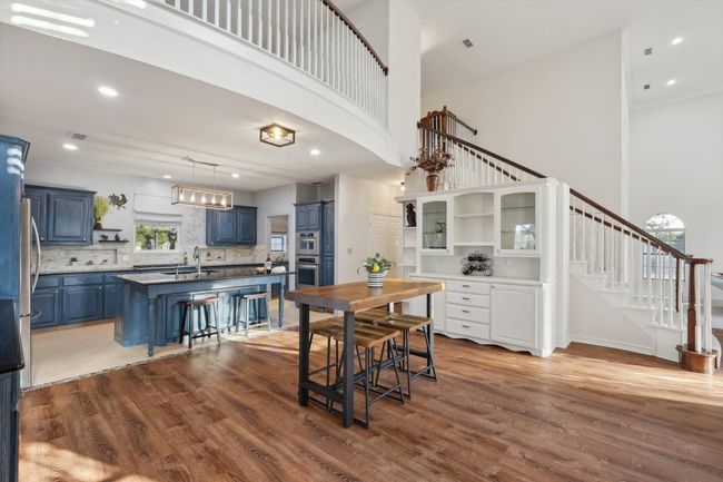 Dining area with a high ceiling, wood finished floors, stairway, and recessed lighting | Image 14