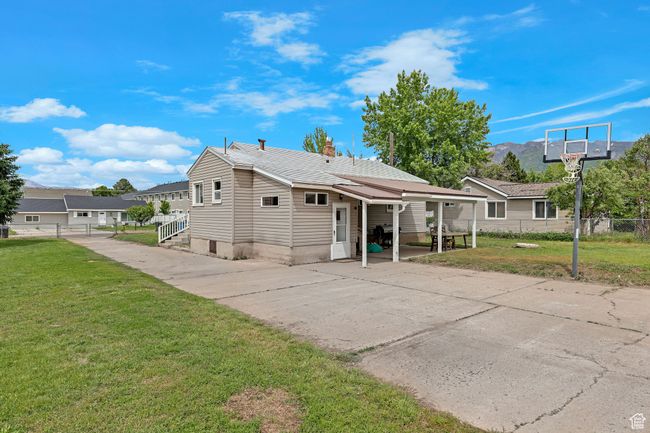 Rear view of property featuring concrete driveway and a chimney | Image 27