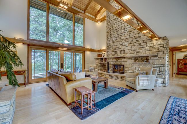 Impressive stone wood burning fireplace with vaulted ceilings in the living room | Image 7