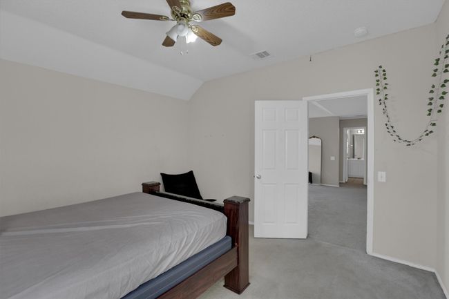 Bedroom with light carpet, lofted ceiling, a ceiling fan, and baseboards | Image 28