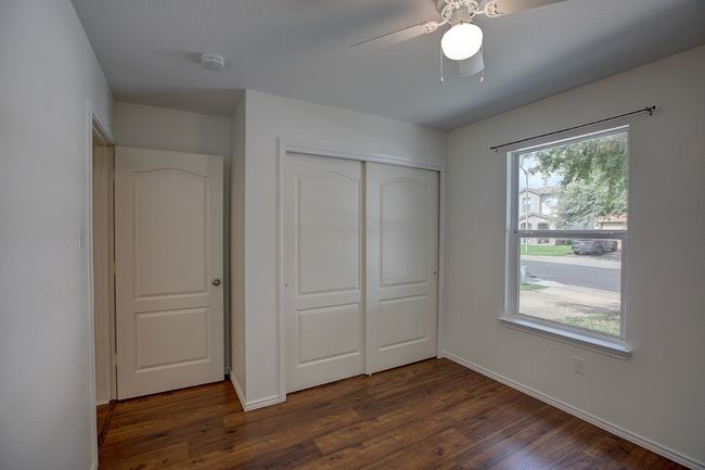 Unfurnished bedroom with a closet, dark wood-type flooring, baseboards, and ceiling fan | Image 36