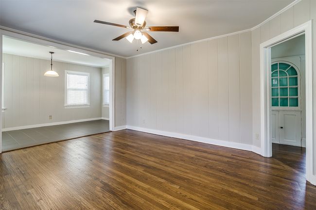 Unfurnished room with dark wood-style flooring, a ceiling fan, and ornamental molding | Image 6