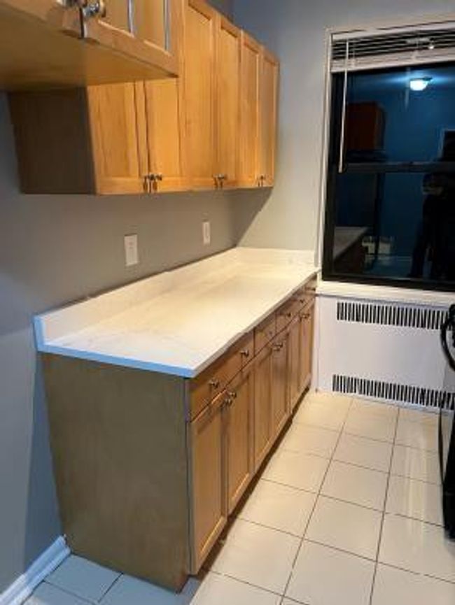 Kitchen featuring radiator, light countertops, and light tile patterned floors | Image 24