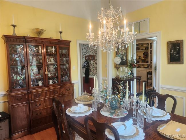 Dining space with a notable chandelier and wood finished floors | Image 8