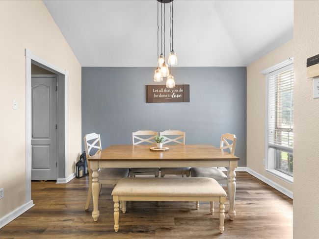 Dining area with vaulted ceiling and wood finished floors | Image 6