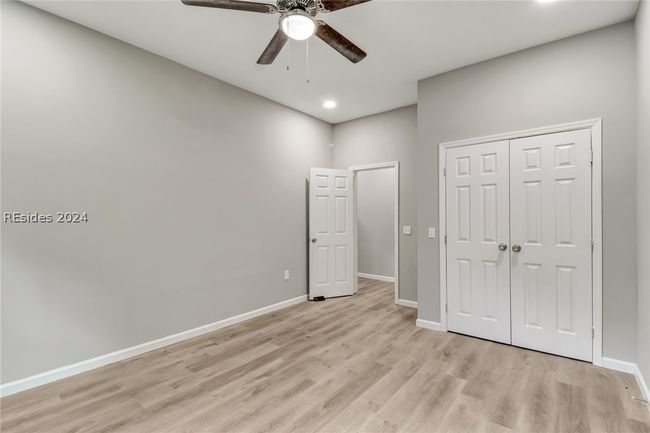 Unfurnished bedroom with ceiling fan, light hardwood / wood-style flooring, and a closet | Image 23