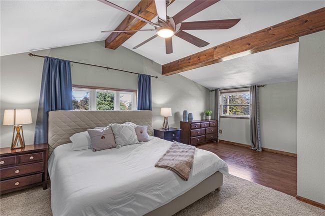 Light & bright owners bedroom with wooden beam accents. | Image 15
