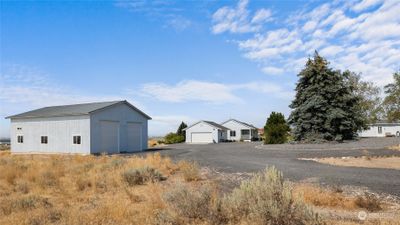 View of driveway coming in and showing additional parking areas along w/home, garage, shop and ADU. | Image 2