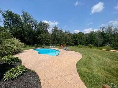 View of swimming pool featuring a yard and a patio area | Image 3