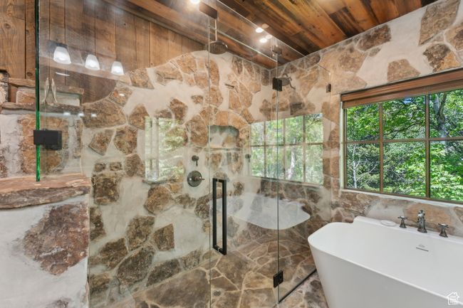 Bathroom featuring wooden ceiling, a marble finish shower, and a freestanding bath | Image 20