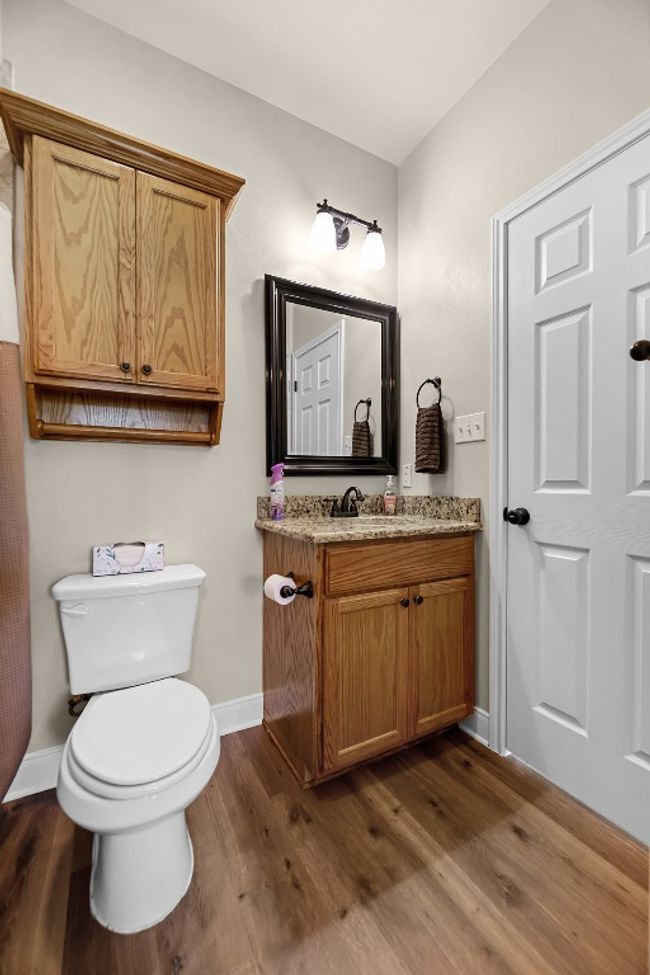 Half bathroom featuring baseboards, toilet, and wood finished floors | Image 18