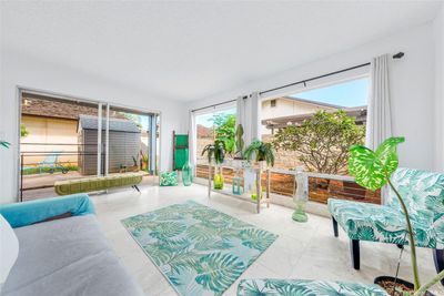 ENHANCED: Living room goes out into the lanai sliding doors and the backyard wraps to the right with a plumeria tree. | Image 2