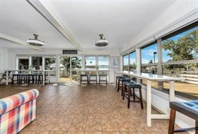 Living area with wall of windows overlooking pickleball court, deck & Lake | Image 12