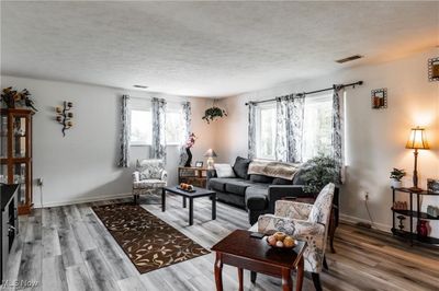 Living room with hardwood / wood-style flooring and a textured ceiling | Image 3