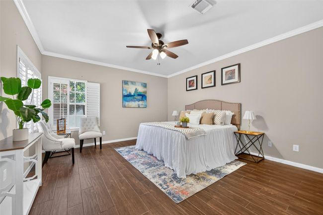 Experience relaxation in this spacious, elegantly designed primary bedroom featuring abundant natural light and stylish decor. | Image 24