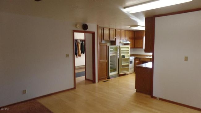 Kitchen featuring light wood-style flooring, under cabinet range hood, baseboards and refrigerator | Image 25