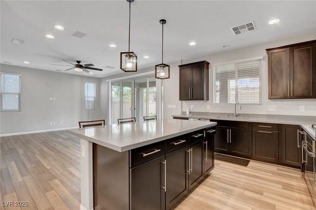 Kitchen featuring light wood-style floors, light countertops, recessed lighting, ceiling fan, and a kitchen island | Image 15