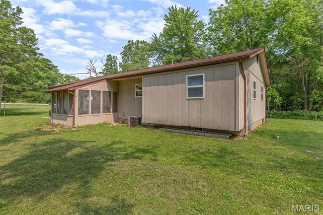 Back of house with a sunroom, a yard, and central AC | Image 6