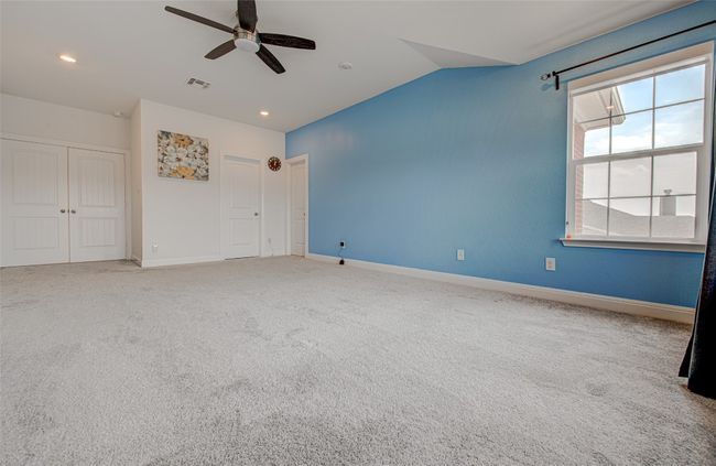 Unfurnished bedroom with a closet, vaulted ceiling, visible vents, and baseboards | Image 26