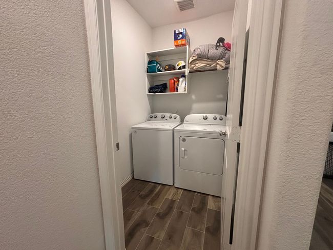 Laundry room featuring washing machine and clothes dryer, wood tiled floors, and a textured wall | Image 20