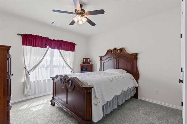 Bedroom featuring light carpet, baseboards, and a ceiling fan | Image 11