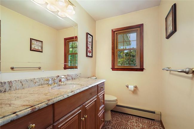 Bathroom with a baseboard radiator, vanity, tile patterned floors, and toilet | Image 18