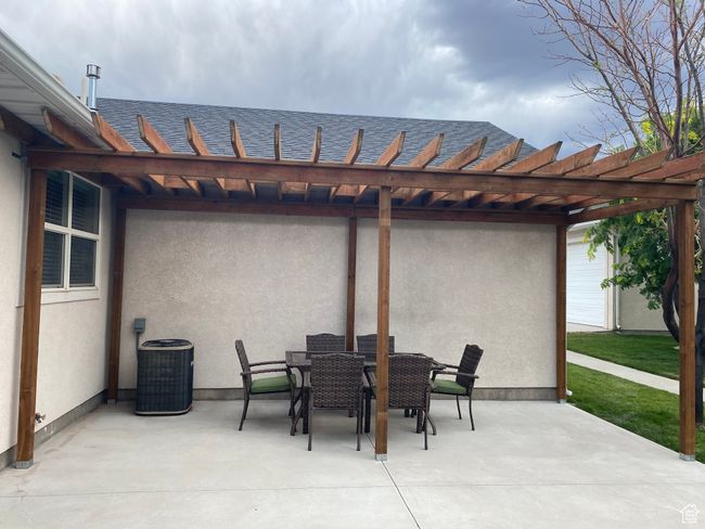 View of patio with cooling unit, outdoor dining area, and a pergola | Image 45