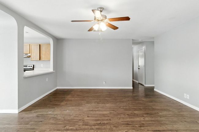 Living room. Opening in the goes to kitchen. Open door in the right background leads to bedrooms and bathrooms. | Image 12