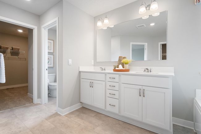 Primary bath with dual sinks, soaking tub, and separate shower. Model photo. Options and colors will vary. | Image 18