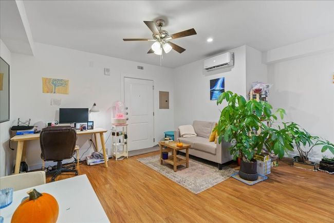 The cozy living room includes recessed light fixtures, a ceiling fan, and is conveniently open to the kitchen. | Image 4
