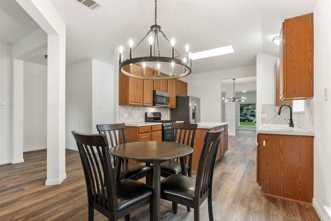Dining area with a chandelier, dark wood finished floors, and lofted ceiling | Image 19